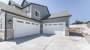 White garage doors with window panels on a multi-story suburban home